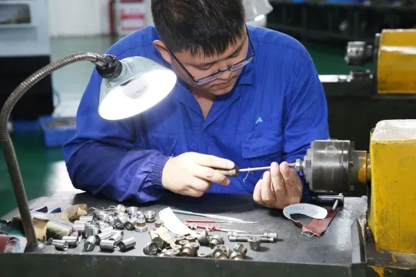 蓝衣技工在台灯下专注组装细小零件特写.jpg 蓝衣技工在台灯下专注组装细小零件特写.jpg